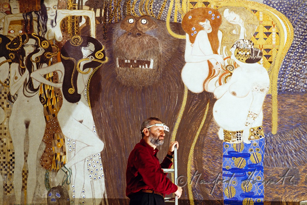 conservator with magnifying glasses checks the painting