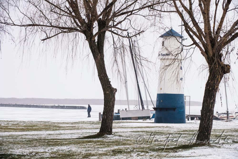 lighthouse and ice-skaters on the lake