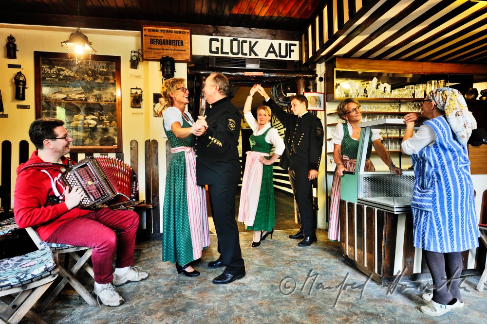 men in miners clothes and women dance in the mining museum